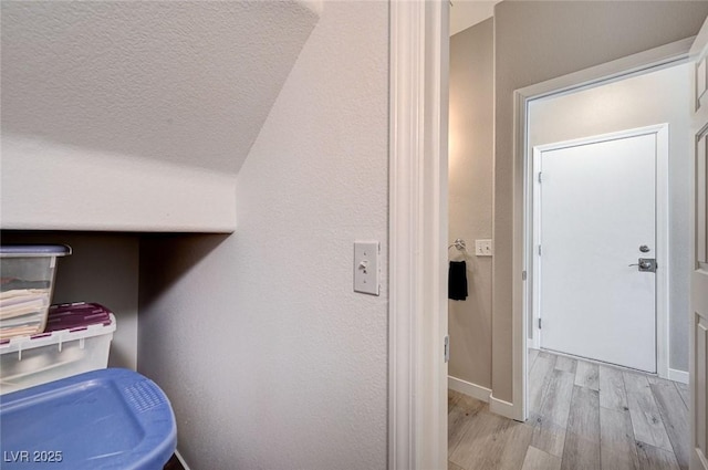 interior space with baseboards and wood finished floors