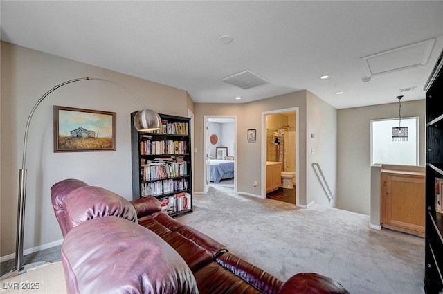 living area featuring recessed lighting, baseboards, light colored carpet, and attic access