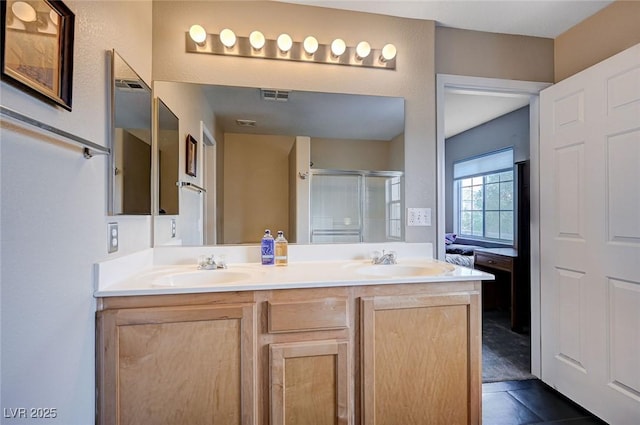 ensuite bathroom with a shower stall, double vanity, visible vents, and a sink