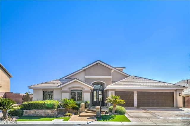 view of front facade featuring a tile roof, stucco siding, concrete driveway, and a garage