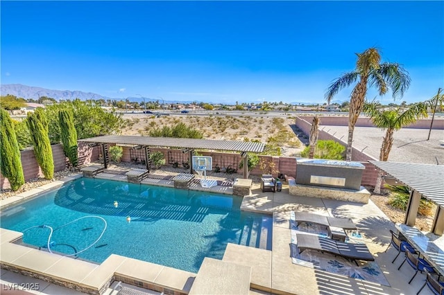 view of swimming pool featuring a patio area, a fenced in pool, a mountain view, and a fenced backyard