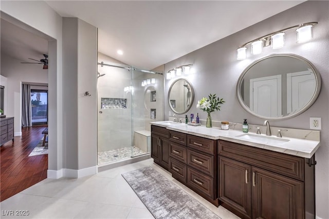 full bathroom with a stall shower, lofted ceiling, a ceiling fan, and a sink