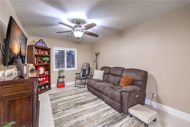 living area featuring baseboards and a ceiling fan