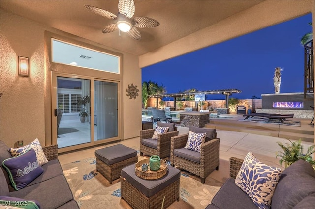 patio at night with visible vents, an outdoor hangout area, and a ceiling fan