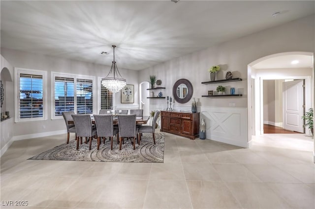 dining space featuring visible vents, baseboards, light tile patterned floors, arched walkways, and a notable chandelier