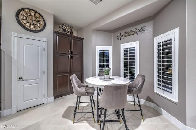 dining room with light tile patterned floors and baseboards