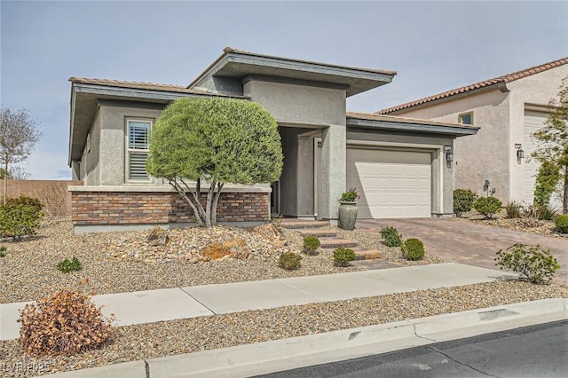 view of front of home with stucco siding, driveway, and an attached garage