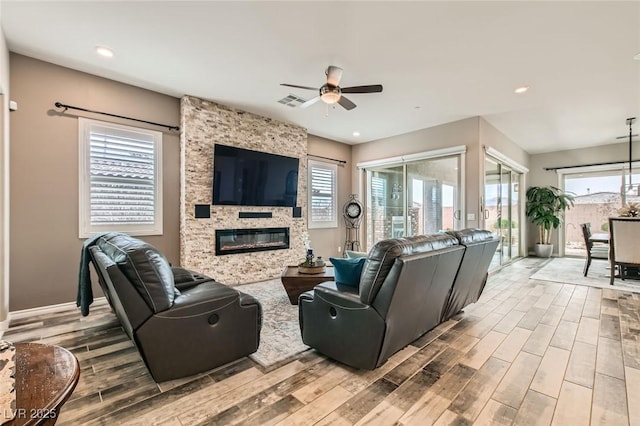 living area with wood finish floors, visible vents, recessed lighting, a large fireplace, and ceiling fan