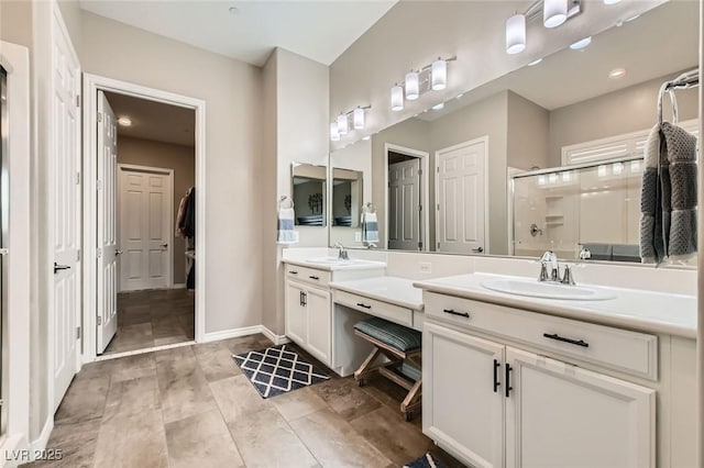 bathroom featuring a closet, a stall shower, vanity, and baseboards