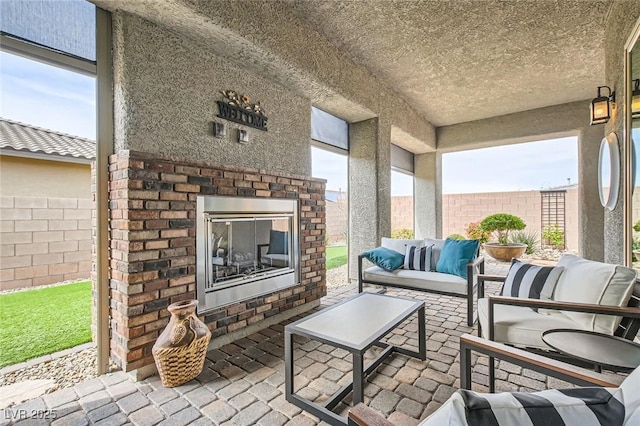 view of patio / terrace featuring an outdoor living space with a fireplace and a fenced backyard