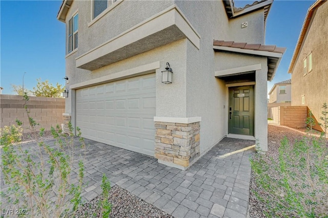 5691 Tinar St, Las Vegas, NV 89113 - doorway to property with an attached garage, stucco siding, and stone siding