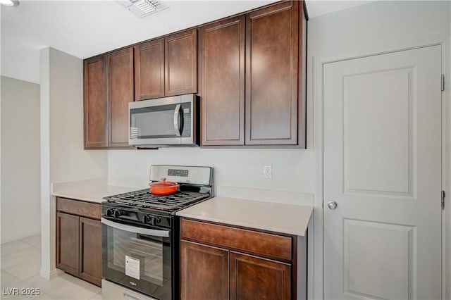 5691 Tinar St, Las Vegas, NV 89113 - kitchen with appliances with stainless steel finishes, light countertops, light tile patterned flooring, and baseboards