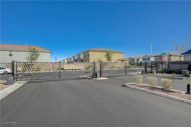 5691 Tinar St, Las Vegas, NV 89113 - view of asphalt road featuring a gate, a gated entry, a residential view, and curbs