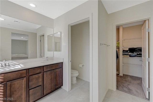 5691 Tinar St, Las Vegas, NV 89113 - ensuite bathroom with double vanity, toilet, a spacious closet, and baseboards