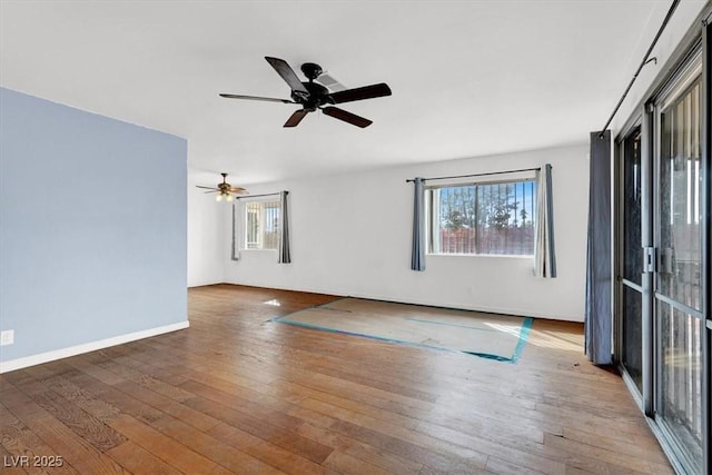 unfurnished room with hardwood / wood-style floors, baseboards, and ceiling fan