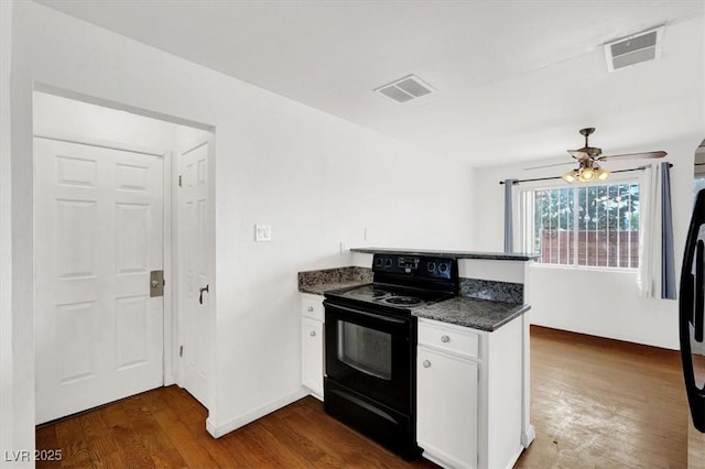 kitchen featuring visible vents, black range with electric cooktop, ceiling fan, dark wood finished floors, and white cabinetry