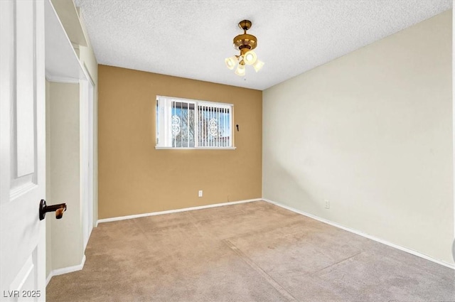 empty room featuring carpet flooring, a textured ceiling, and baseboards