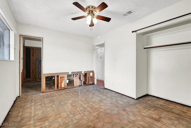 unfurnished bedroom featuring visible vents, tile patterned floors, ceiling fan, a closet, and a textured ceiling