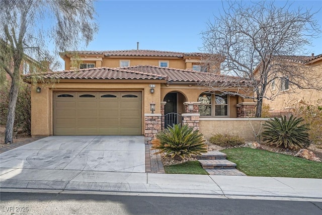 mediterranean / spanish house with a tile roof, a garage, driveway, and stucco siding