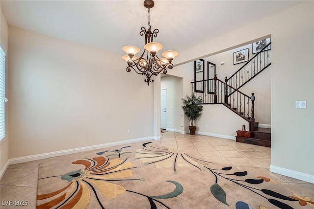 interior space with tile patterned flooring, a chandelier, stairway, and baseboards