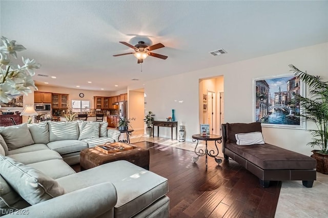 living room featuring visible vents, light wood-style flooring, recessed lighting, baseboards, and ceiling fan