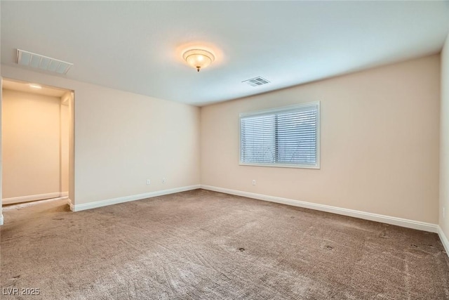 empty room with visible vents, baseboards, and carpet