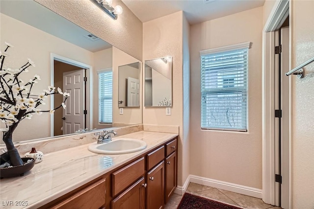 bathroom featuring tile patterned floors, visible vents, baseboards, and vanity