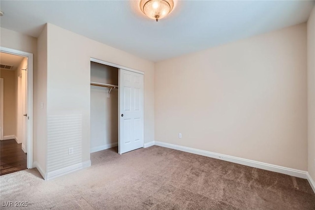 unfurnished bedroom featuring carpet, baseboards, and a closet