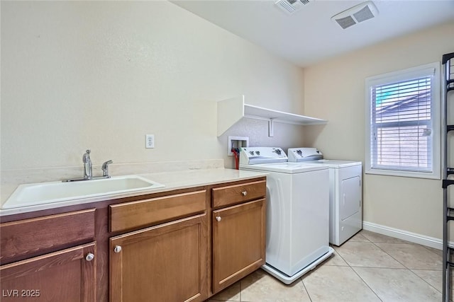 washroom with washing machine and clothes dryer, visible vents, cabinet space, and a sink