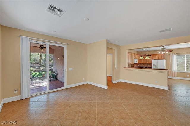 unfurnished living room with light tile patterned floors, visible vents, baseboards, and a ceiling fan