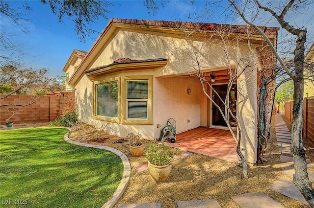 back of property with a patio, a yard, a fenced backyard, and stucco siding