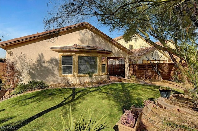 view of front of house with stucco siding, a front lawn, and fence