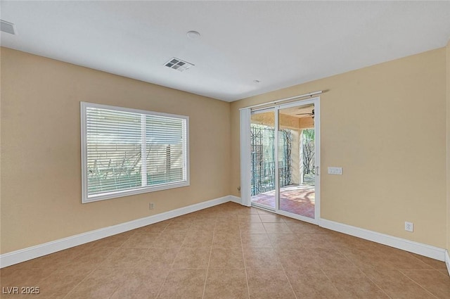 spare room featuring tile patterned flooring, baseboards, and visible vents