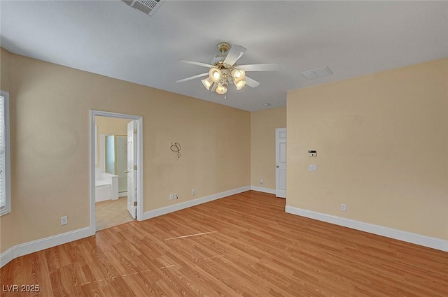 unfurnished room with visible vents, a ceiling fan, light wood-type flooring, and baseboards