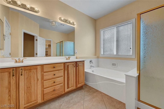 bathroom with double vanity, a stall shower, a bath, tile patterned floors, and a sink