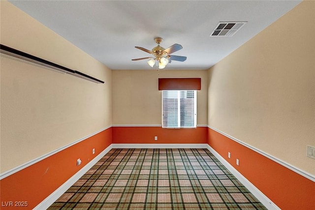 unfurnished room with visible vents, baseboards, and ceiling fan