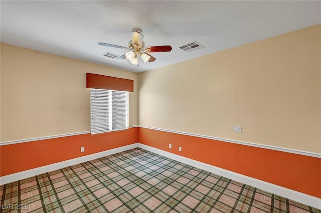 unfurnished room with visible vents, baseboards, and ceiling fan