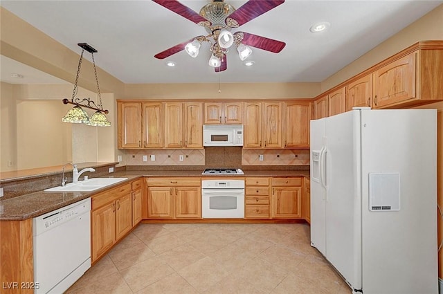 kitchen with white appliances, a peninsula, ceiling fan, decorative backsplash, and a sink