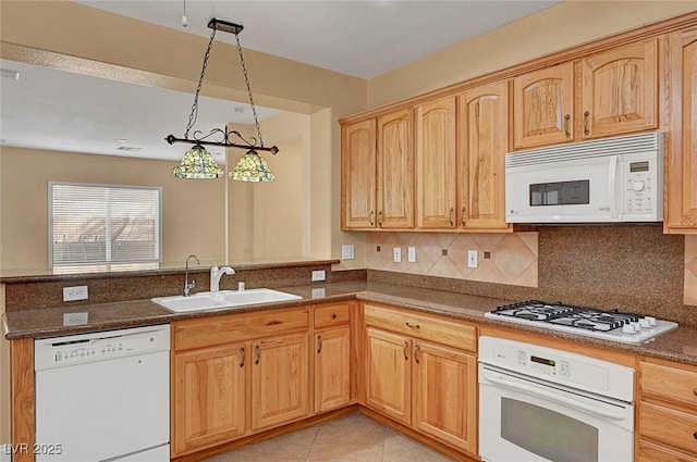 kitchen with a sink, backsplash, white appliances, a peninsula, and light tile patterned floors