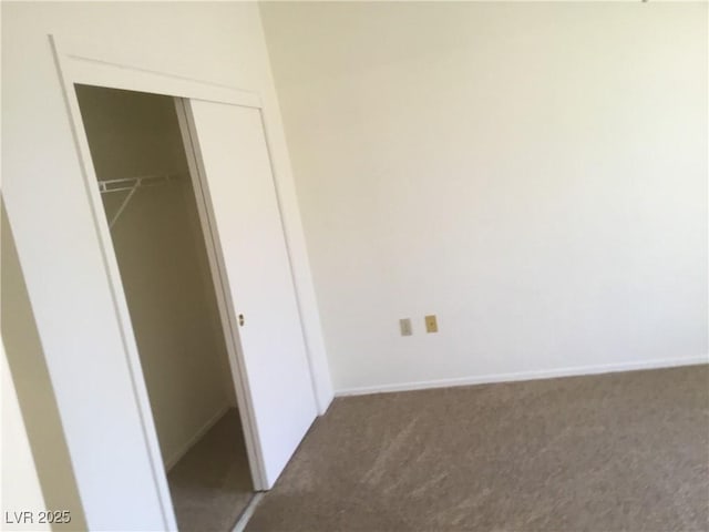 unfurnished bedroom with a closet, baseboards, and carpet