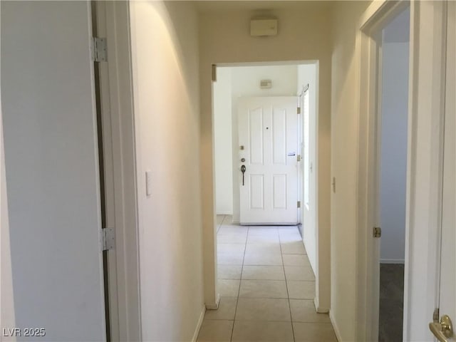 hall with light tile patterned flooring and baseboards