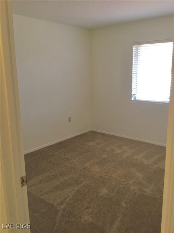 spare room with baseboards and carpet