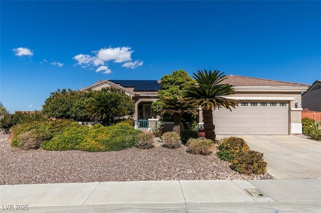 obstructed view of property featuring solar panels, concrete driveway, an attached garage, and stucco siding