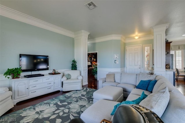 living area featuring dark wood-style floors, visible vents, ornate columns, and ornamental molding