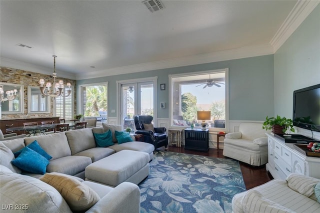 living room with visible vents, a notable chandelier, dark wood-style flooring, and wainscoting