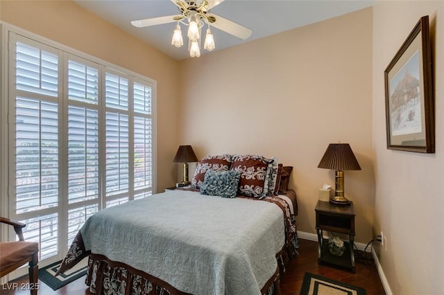 bedroom with a ceiling fan, baseboards, and wood finished floors