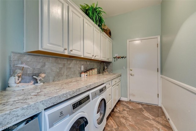 clothes washing area with a sink, cabinet space, baseboards, and washer and clothes dryer