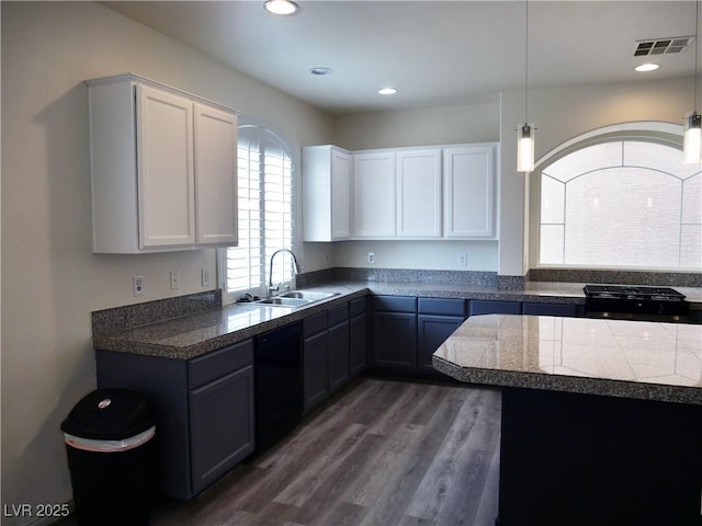 kitchen featuring visible vents, dark wood-type flooring, a sink, black dishwasher, and tile countertops