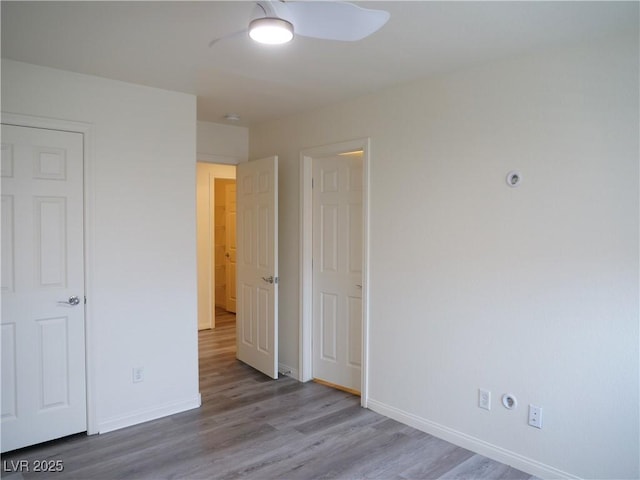 unfurnished bedroom with ceiling fan, baseboards, and wood finished floors