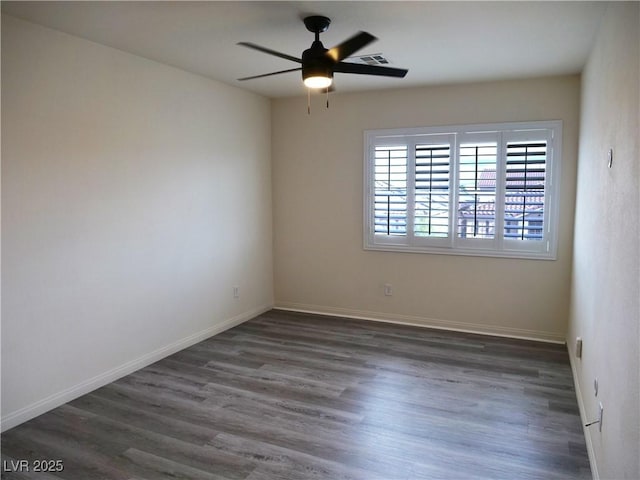 empty room featuring a ceiling fan, visible vents, wood finished floors, and baseboards